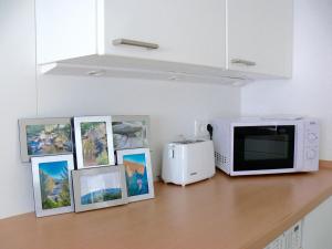 a kitchen counter with a microwave and framed pictures at Ferienwohnung Hudewusch in Bad Harzburg