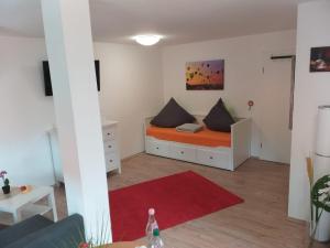 a small room with a bed with an orange mattress at Fewo kleine Oase in Wernigerode