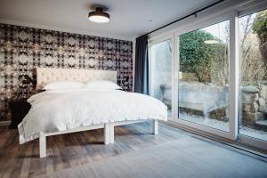 a bedroom with a white bed and a window at The Bonnie Badger in Gullane