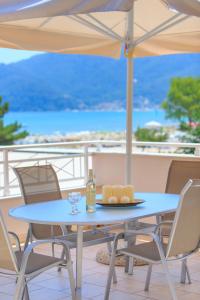 einen blauen Tisch mit einer Flasche Wein und Käse in der Unterkunft Sunny by the Beach in Chrisi Ammoudia