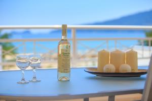 a bottle of wine and two glasses on a table at Sunny by the Beach in Chrysi Ammoudia