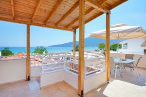 a patio with a table and an umbrella at Sunny by the Beach in Chrysi Ammoudia