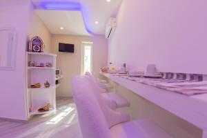 a dressing room with purple chairs and a long counter at Civico 364 in Naples