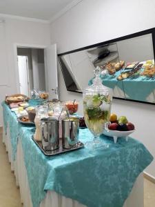 una mesa con un mantel azul con comida. en Hotel Capri, en Nova Santa Medianeira