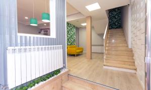 a hallway with stairs and a yellow chair at Hostal Viena in Soria