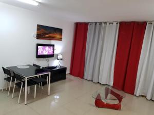 a living room with red and white curtains and a table at Lev Eilat Apartments 5 in Eilat