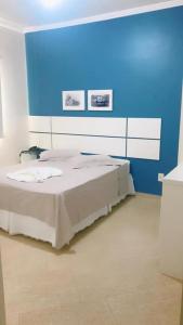1 dormitorio con 1 cama con pared azul en Hotel Capri, en Nova Santa Medianeira