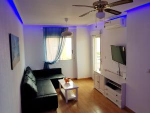 a living room with a couch and a tv at Apartament Veneziola in San Javier