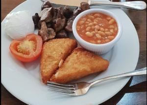 a plate of food with beans beans and a bowl of soup at Esplanade Hotel in Clacton-on-Sea