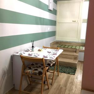 ein Zimmer mit einem Tisch, Stühlen und einer gestreiften Wand in der Unterkunft Suite 01 in Montesarchio