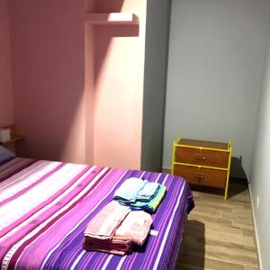 1 dormitorio con 1 cama con sábanas moradas y vestidor en Suite 01 en Montesarchio