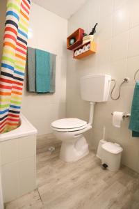 een badkamer met een toilet en een regenboog douchegordijn bij 7564 Post-its in Lissabon