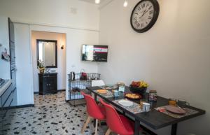 ein Esszimmer mit einem Tisch und einer Uhr an der Wand in der Unterkunft Appartamento ClaRa in Alghero