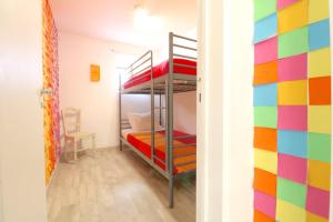 リスボンにある7564 Post-itsの二段ベッドが備わるカラフルな壁の客室です。
