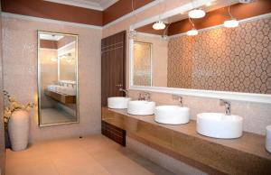 a bathroom with three sinks and a mirror at Hotel Świętokrzyski Dwór in Nowa Słupia +34 photos