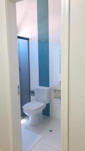 baño con aseo y pared de azulejos verdes en Hotel Capri, en Nova Santa Medianeira
