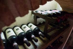 a bunch of wine bottles on a wooden shelf at Bernardone in Camaiore