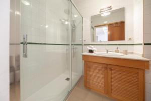 Un baño con ducha de cristal y lavabo. en Bravissimo Sunset, en Girona 28 fotos más