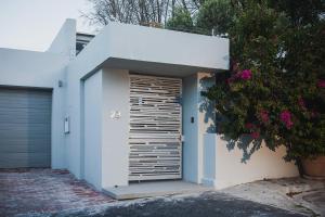 Casa blanca con garaje con puerta en 23 Grace, en Ciudad del Cabo