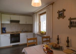 - une cuisine avec une table et une plaque de cuisson dans l'établissement Ferienhof Am Holderbusch, à Füssen