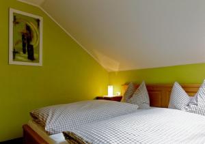 a bedroom with a white bed and green walls at Ferienhof Am Holderbusch in Füssen