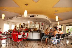 eine Gruppe von Personen, die in einem Restaurant an Tischen sitzen in der Unterkunft Hotel Vezia in Lugano