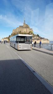 a bus parked on the side of a road near the ocean at homedelabaie in Pontorson