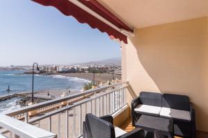 balcón con sillas y vistas a la playa en Piso en primera linea con vistas directas al mar, en Melenara