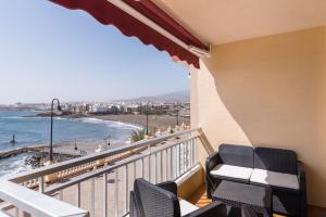 balcón con sillas y vistas a la playa en Piso en primera linea con vistas directas al mar en Melenara