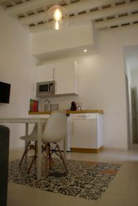 a kitchen with a table and chairs in a room at Loft Cádiz in Cádiz