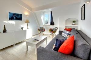 Una sala de estar con un sofá gris y una mesa. en Apartamentos Tucha, en Albufeira