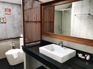 La salle de bains est pourvue d'un lavabo, de toilettes et d'un miroir. dans l'établissement The Nest Samui, à Bangrak Beach