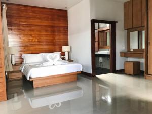 a bedroom with a bed with a wooden headboard at The Nest Samui in Bangrak Beach