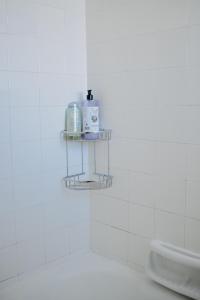 a white tiled bathroom with a shelf on the wall at BEST HOUSE, KAPODISTRIOU, PSILA ALONIA in Patra