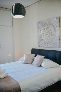duże łóżko z białą pościelą i poduszkami w obiekcie BEST HOUSE, KAPODISTRIOU, PSILA ALONIA w mieście Patras