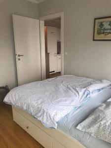 ein Schlafzimmer mit einem Bett mit einer weißen Tagesdecke in der Unterkunft Modern apartment with balcony in Wien