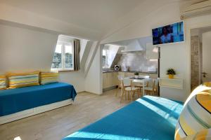 1 dormitorio con 1 cama azul y cocina en Apartamentos Tucha, en Albufeira