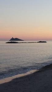 a beach with an island in the ocean at sunset at Villa Pula Mare in Pula