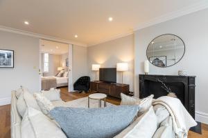 a living room with a couch and a mirror at ALTIDO Luxury 2 bed flats with terraces near Piccadilly Circus in London