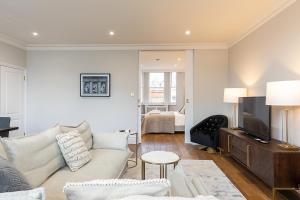 a living room with a couch and a tv at ALTIDO Luxury 2 bed flats with terraces near Piccadilly Circus in London