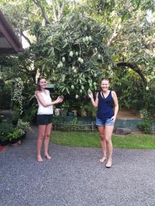 two women standing in front of a fruit tree at Kanthi Holiday Rest Homestay in Mirissa