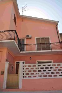 Casa de color rosa con balcón en B&B Il Gabbiano, en SantʼAntìoco