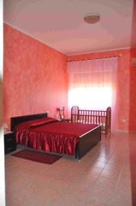 1 dormitorio rojo con 1 cama grande y ventana en B&B Il Gabbiano, en SantʼAntìoco
