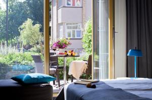 a bedroom with a bed and a view of a balcony at Kurshi Hotel & Spa in Jūrmala