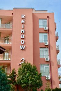a tall red building with a sign on it at Rainbow 2 Holiday Complex in Sunny Beach