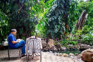 a man sitting at a table next to a stream at Cozycomo Bangkok in Bangkok