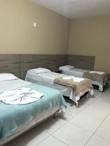 una habitación de hospital con tres camas. en Conquista Palace Hotel, en Vitória da Conquista