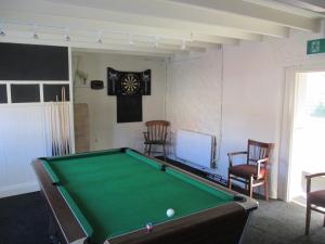 a pool table in a room with chairs and a clock at Wentworth arms in Malton