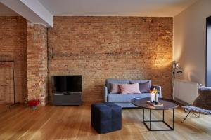 a living room with a couch and a brick wall at Søndergade - “strøget” in Aarhus
