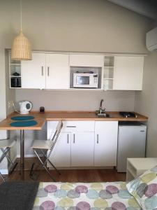 a kitchen with white cabinets and a table with a microwave at Las Eduardas in La Paloma